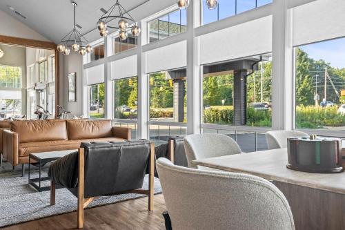 a living room with a couch and chairs and windows at The Vic By Kasa in Traverse City