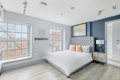 a bedroom with a white bed and blue walls at The King Street House By Kasa in Alexandria