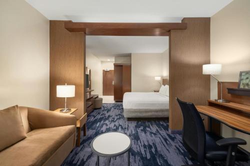 a hotel room with a couch and a bed at Fairfield Inn & Suites by Marriott West Monroe in West Monroe