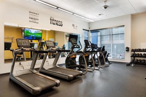 a row of treadmills in a gym with treadleys at Kasa Westown Milwaukee in Milwaukee