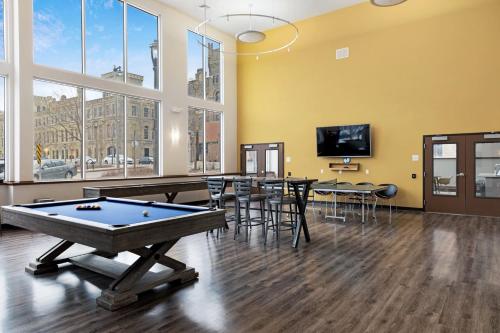 a pool table in a room with tables and chairs at Kasa Westown Milwaukee in Milwaukee