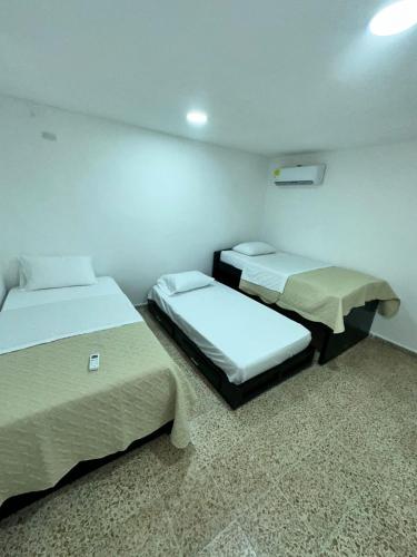 a room with two beds in a room at Hotel H&H in Cartagena de Indias