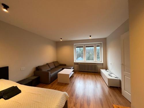 a room with a bed and a couch and a window at Cozy Stay Dubulti in Jūrmala