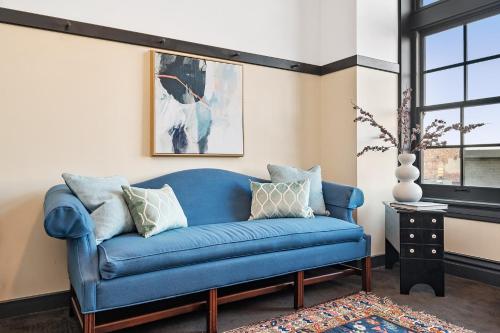 a blue couch in a living room with a window at The Maverick By Kasa in Pittsburgh