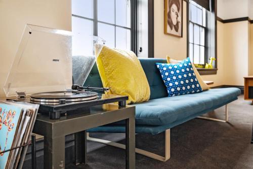 a living room with a blue couch and a table at The Maverick By Kasa in Pittsburgh