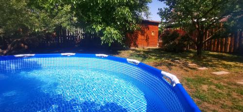 a blue swimming pool in a yard with a fence at Velencei Odú in Velence