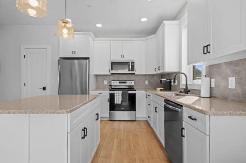 a kitchen with white cabinets and stainless steel appliances at The Loop Downtown By Kasa in Traverse City