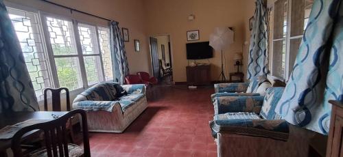 a living room with two couches and a television at Nadhi Teera Riverside Stay in Kushālnagar