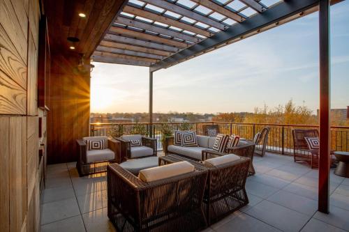 a patio with chairs and tables on a balcony at The Bell Athens By Kasa Living in Athens