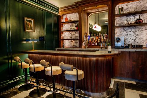 a bar with a row of stools in a room at The Bell Athens By Kasa Living in Athens