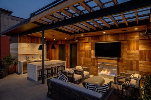 a patio with a fireplace and a tv on a wall at The Bell Athens By Kasa Living in Athens