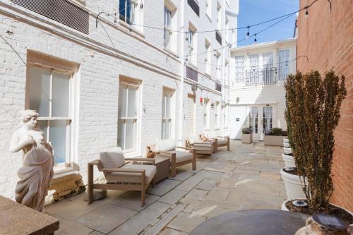 a courtyard with furniture and windows on a building at The King Street House By Kasa in Alexandria