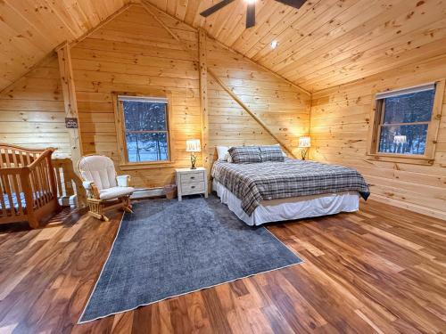 a bedroom in a log cabin with a bed and a chair at 2S New log cabin in Bethlehem - privacy, firepit, great location! in Bethlehem