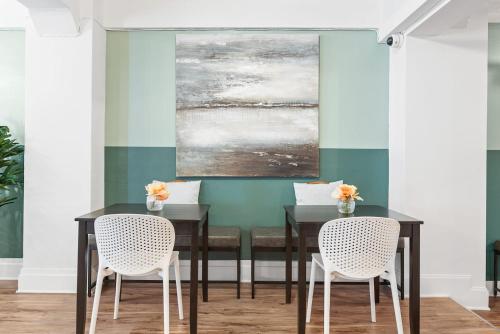 a dining room with a black table and two white chairs at Kasa La Monarca San Francisco in San Francisco