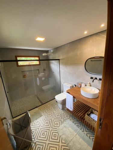 ein Badezimmer mit Dusche, Waschbecken und Toilette in der Unterkunft Casa da Rota dos Ipês in Domingos Martins