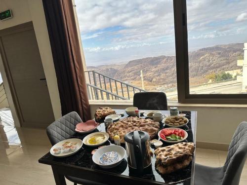una mesa con comida delante de una ventana en Mountain Echo Inn, en Taiyiba