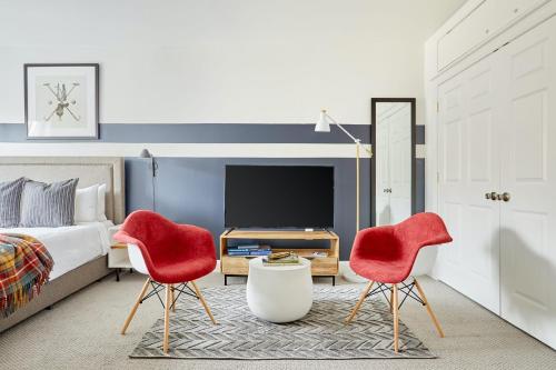 a bedroom with two red chairs and a bed at Kasa Del Ray Alexandria in Alexandria