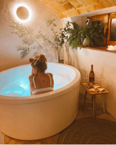 a woman sitting in a bath tub in a bathroom at Halona Casa Rural in Bullas