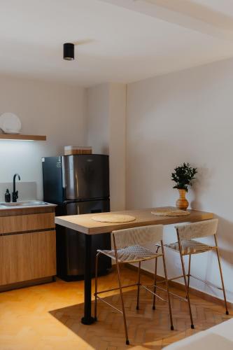 a kitchen with a table and two chairs and a refrigerator at Pranik Living Wellness Coliving Laureles Medellin in Medellín