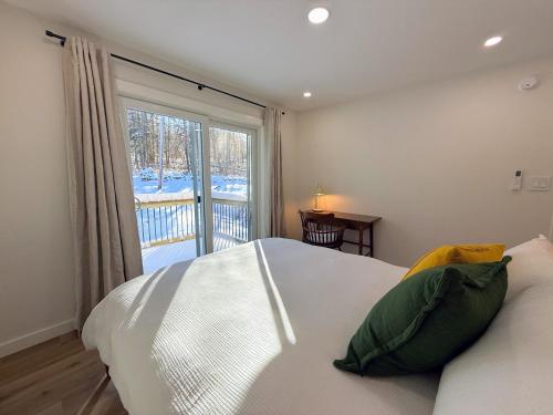 a bedroom with a bed and a large window at 2T Bethlehem Retreat with Stunning Sunset Views in the Heart of the White Mountains in Bethlehem