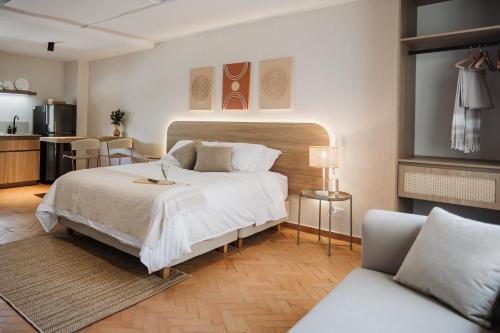 a bedroom with a large bed and a kitchen at Pranik Living Wellness Coliving Laureles Medellin in Medellín
