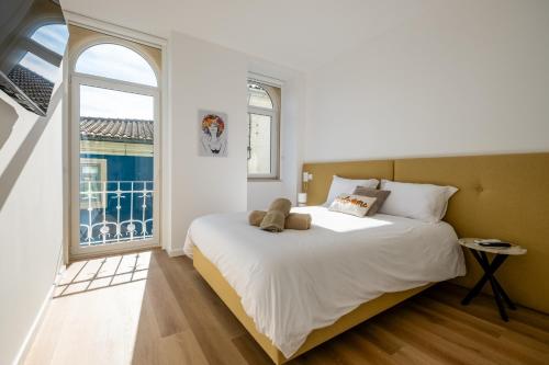 a bedroom with a bed with a teddy bear on it at Pharmácia- Alojamento local in Miranda do Corvo