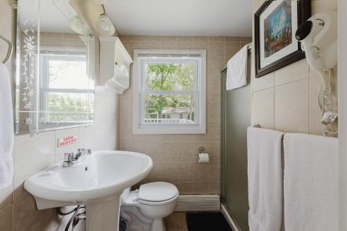 Hamptons Vacation Inn في خلجان هامبتون: حمام مع حوض ومرحاض ونافذة