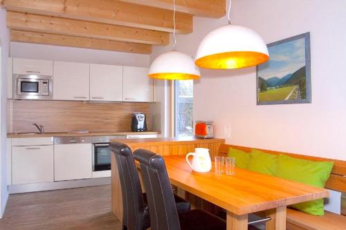 een keuken met een houten eettafel met stoelen bij Ferienhaus Alpenflair bei Schliersee in Schliersee