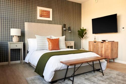 a bedroom with a large bed and a flat screen tv at Kasa Cadillac Square Detroit in Detroit