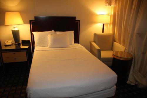 a bedroom with a large white bed with two lamps at Bedford Plaza Hotel - Boston in Bedford