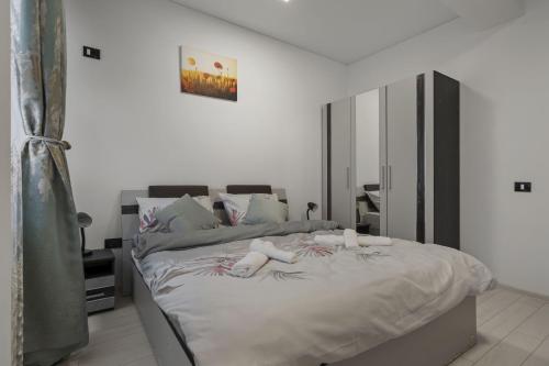a bedroom with a large bed with white sheets at Apartament Militari Residence in Dudu