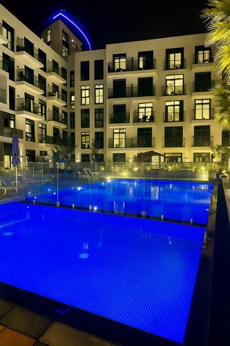 a swimming pool in front of a building at night at Stunning Studio in Dubai in Dubai