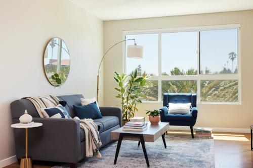 a living room with a blue couch and a chair at Kasa University-Airport Santa Clara in Santa Clara