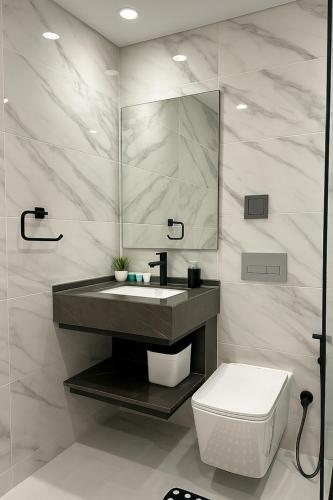 a bathroom with a sink and a toilet and a mirror at Stunning Studio in Dubai in Dubai