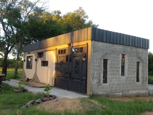 a small brick building with a large door at Cabaña Mbaretecua in Paso de la Patria