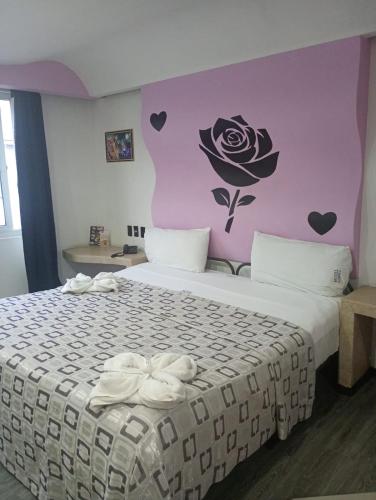 a bedroom with a bed with a flower on the wall at Hotel Florencia in Mexico City