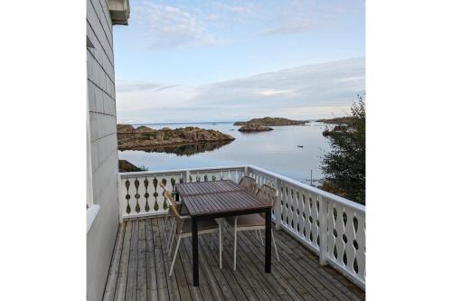 einen Tisch auf einem Balkon mit Blick auf das Wasser in der Unterkunft Coastal Comfort Ure in Vestvågøya