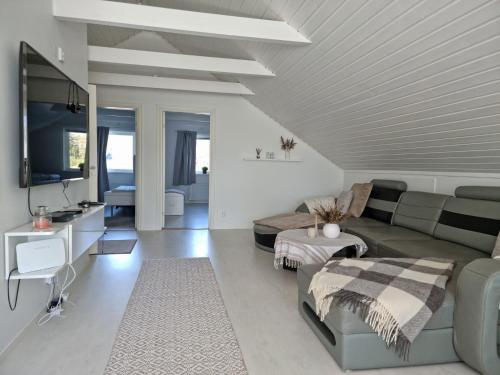 Cosy rural apartment close to Nösund SE09122 في Strand: غرفة معيشة مع أريكة وتلفزيون