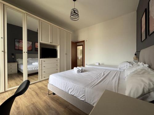 a bedroom with a large white bed and a desk at Bilocale luminoso ed elegante-Parcheggio gratuito in La Spezia