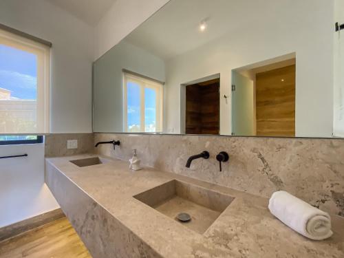 a bathroom with two sinks and a large mirror at Villas Tropical By Andiani in Cancún