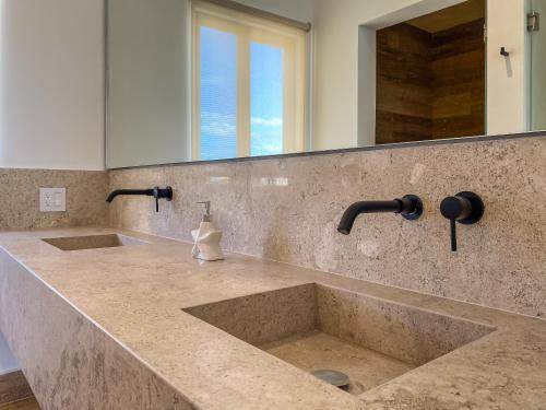 a kitchen counter with two sinks and a mirror at Villas Tropical By Andiani in Cancún