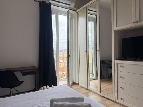 a bedroom with a large mirror in front of a window at Bilocale luminoso ed elegante-Parcheggio gratuito in La Spezia