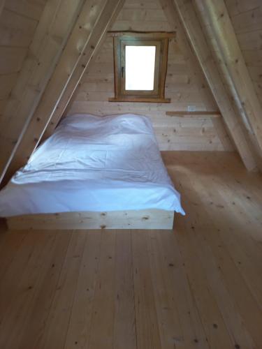 a bed in a wooden room with a window at Chalet Čilac in Žabljak