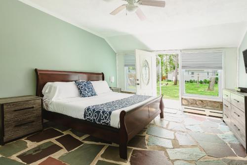 Hamptons Vacation Inn في خلجان هامبتون: غرفة نوم بها سرير ومروحة سقف