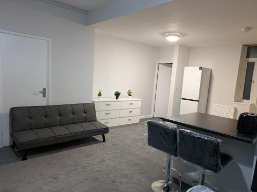 a living room with a couch and a table at Modern One Bedroom Flat With Garden in Cardiff
