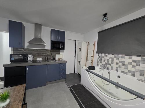 a kitchen with a tub and a kitchen with blue cabinets at El nido de la Galería in Setenil