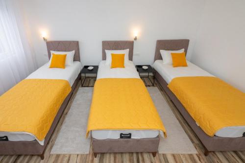 two twin beds in a room with yellow pillows at Apartment Center in Kolašin
