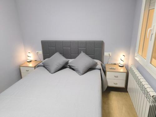 a bedroom with a large white bed with two night stands at Luxury Monte 65 in Tomelloso