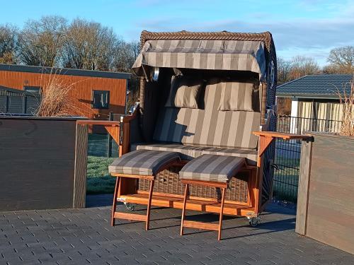 a pair of chairs sitting in a tent on a patio at Chalet Black Pearl Seeparx Süsel nahe Scharbeutz und Haffkrug Hund Zaun umzäunt in Süsel