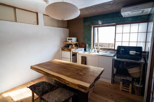 a kitchen with a wooden table in a room at あわ居別棟 一棟貸し in Gujo